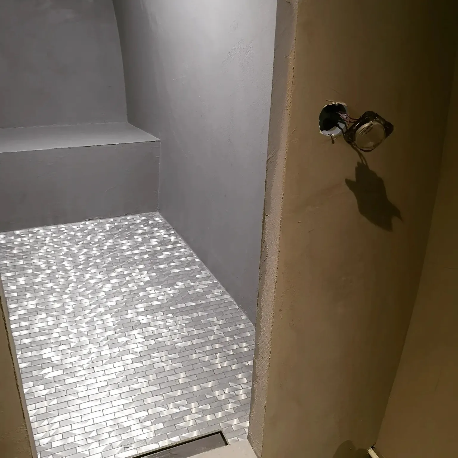 Détail d’une douche avec assise et mosaïque