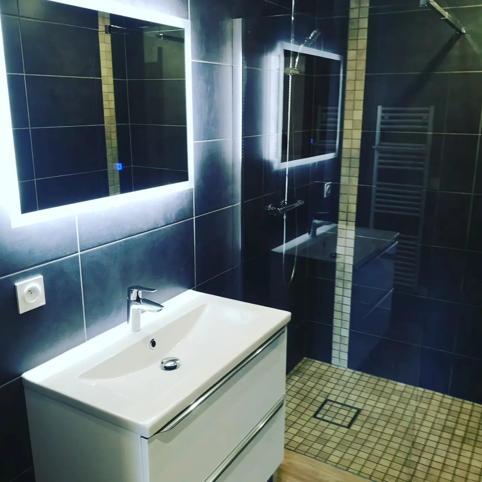 Salle de bains contemporaine noire avec meuble vasque et miroir éclairé